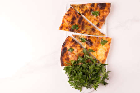 Traditional georgian cuisine. Khachapuri Megrelian with spinach and parsley. Pita bread with cheese