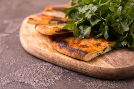 Traditional georgian cuisine. Khachapuri Megrelian with spinach and parsley. Pita bread with cheese