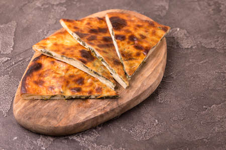 Traditional georgian cuisine. Khachapuri Megrelian with spinach and parsley. Pita bread with cheese