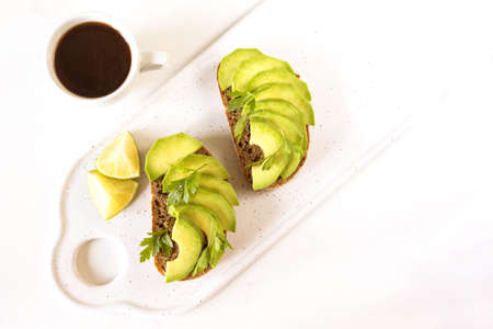 Healthy breakfast toasts with avocado, lime and coffee. White background. Vegetarian, diet