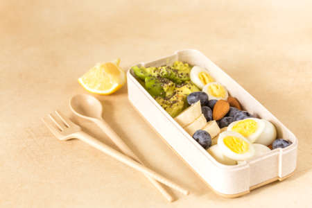 Avocado, boiled quail eggs with banana, blueberry and almond on marble background. Ketogenic diet. Low carb high fat breakfast. Healthy food conceptの写真素材