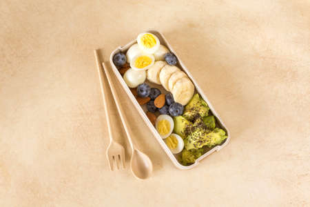 Avocado, boiled quail eggs with banana, blueberry and almond on marble background. Ketogenic diet....
