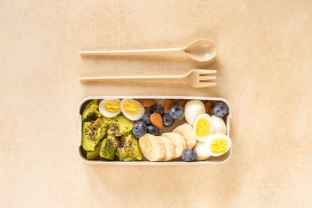 Avocado, boiled quail eggs with banana, blueberry and almond on marble background. Ketogenic diet. Low carb high fat breakfast. Healthy food conceptの写真素材