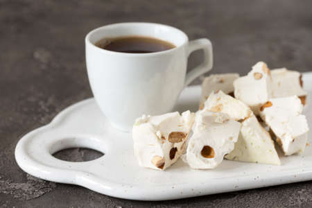 Italian festive torrone. Nougat with almonds and cup of coffee. Breakfast conseptの写真素材