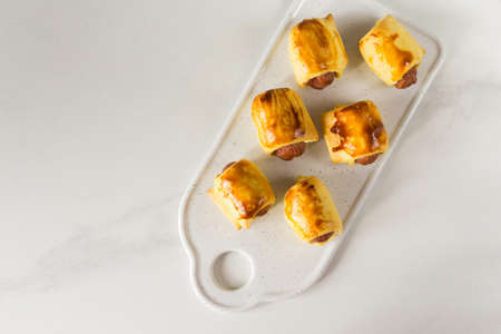Pastry wrapped sausage rolls, fried sausage pies in dough. Junk food concept