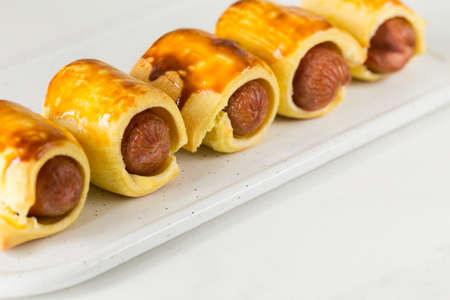 Pastry wrapped sausage rolls, fried sausage pies in dough. Junk food conceptの写真素材