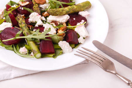 Green vegan salad with asparagus, feta, beetroot, arugula, lime and nuts. The concept of dietary vegetarian food. Top viewの写真素材