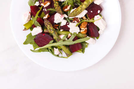 Green vegan salad with asparagus, feta, beetroot, arugula, lime and nuts. The concept of dietary vegetarian food. Top viewの写真素材