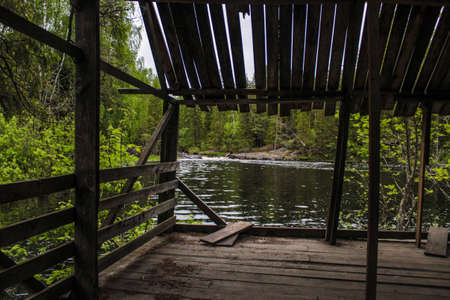 Old wooden arbor on the lake shore in the forest, Republic of Karelia, Russiaの写真素材