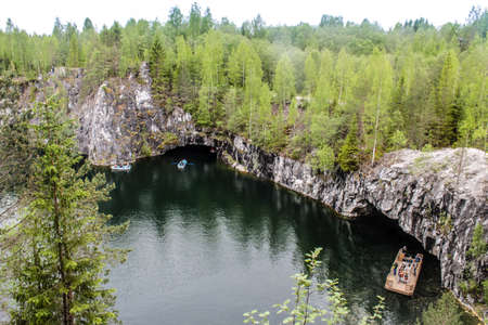 People in a boat sail in the lake, Marble Canyon Ruskeala, Republic of Karelia, Russiaの写真素材