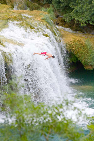 Man leaping from rock to water  Waterfall Krka, National Park, Croatia のeditorial素材