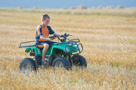 Boy riding a quad bikeの写真素材