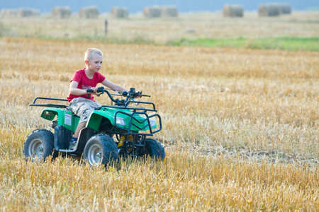 Boy riding a quad bike の写真素材