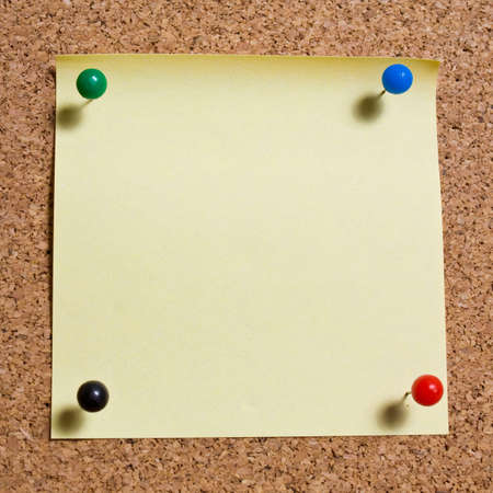 Yellow memo stick on cork board background の写真素材