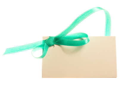Blank gift tag tied with a bow of satin ribbon. Isolated on white, with soft shadow の写真素材