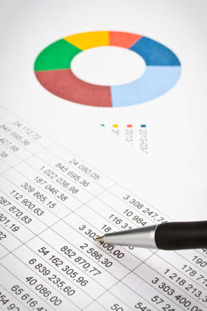 Businessman showing a diagram on a financial report using a pen の写真素材