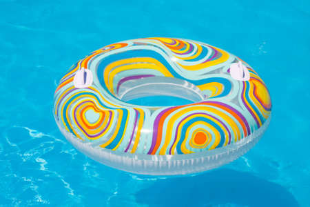 Colorful inflatable ball and round tube floating in swimming pool の写真素材
