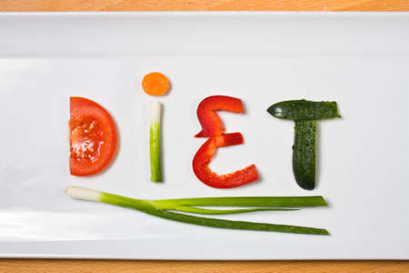 Plate with vegetables and word diet over wooden background の写真素材