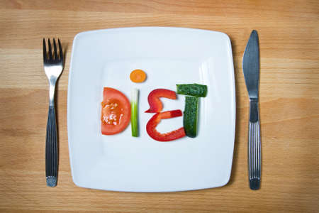 Plate with vegetables and word diet over wooden background の写真素材
