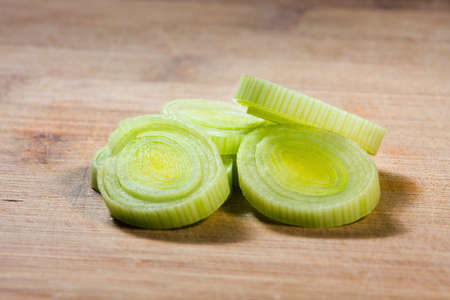 Fresh sliced leeks on a wooden bread board の写真素材