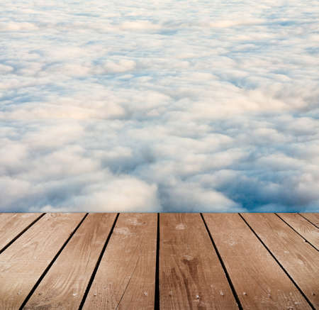 empty wooden deck table with clouds. Ready for product montage display. 