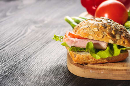 A fresh deli sandwich with ham, radish, tomatoesの写真素材