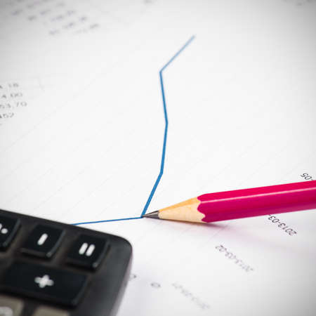 Businessman showing a diagram on a financial report using a pen の写真素材