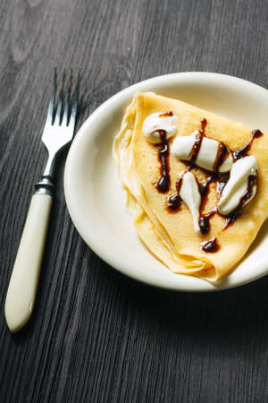 Closeup of chocolate pancakes with whipped creamの写真素材