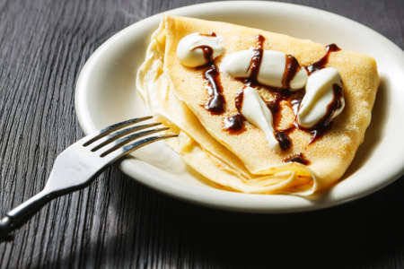 Closeup of chocolate pancakes with whipped creamの写真素材