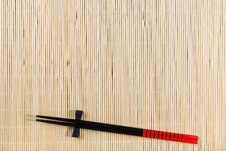 Two chopsticks on sushi mat backgroundの写真素材