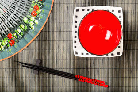 Two chopsticks on sushi mat background with plateの写真素材