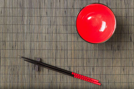 Two chopsticks on sushi mat background with plateの写真素材