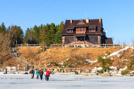 Morskie Oko Lake, POLAND - MARCH 14: Unidentified group of tourists are walking on the frozen Morskie Oko Lake, Poland on March 14, 2014.Tatra Mountains is very popular travel destination.のeditorial素材