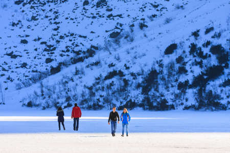 Morskie Oko Lake, POLAND - MARCH 14: Unidentified group of tourists are walking on the frozen Morskie Oko Lake, Poland on March 14, 2014.Tatra Mountains is very popular travel destination.のeditorial素材