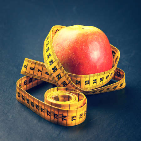 apple with yellow measuring tape