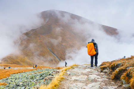 Tatra Mountains, Poland - October 10: Tourists walking in a foggy day to the top of the Kasprowy Wierch in Tatra Mountains on October 10, 2015, Poland.のeditorial素材