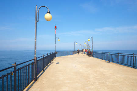 Miedzyzdroje, Poland - April 09, 2016: People walking on a concrete pier in Miedzyzdroje. Town and a seaside resort in Poland on the island of Wolinのeditorial素材