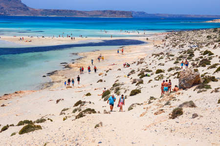 Unidentified people sunbathing and strolling along the beach in Balos Lagoon on Crete, Greeceの写真素材