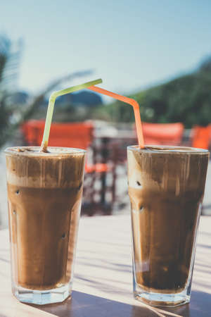 Coffee frappe, greek cuisine on the table at the beach, vintage lookの写真素材