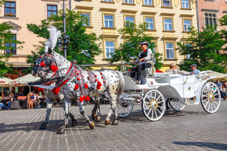 KRAKOW, POLAND - September 16, 2016: Horse carriages at main square in Krakow in a summer day,...