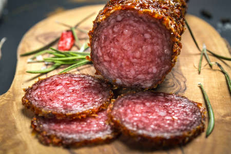 dried salami crusted in ground red pepper on dark backgroundの写真素材