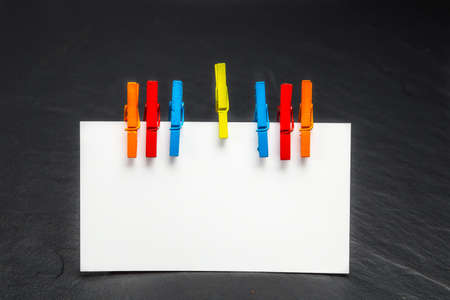 close up of a note paper and clothes pegs on a black backgroundの写真素材