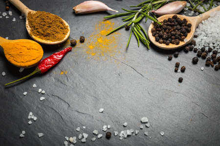 spices and herbs over black stone background, top view with copy spaceの写真素材