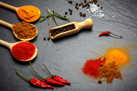 spices and herbs over black stone background, top view with copy spaceの写真素材