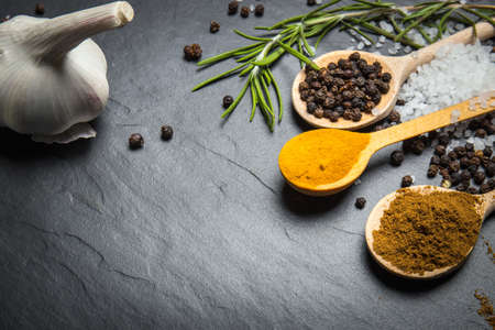 spices and herbs over black stone background, top view with copy spaceの写真素材