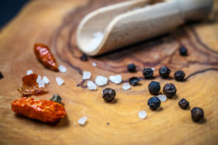 Chili with black pepper and salt on rustic wooden table. Overhead view food photography.