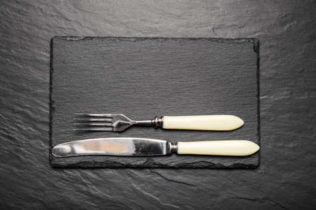 black slate board for serving with fork and knife, top view