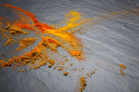powdered spices scattered on a black board