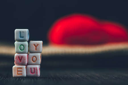 Word Love written in ceramic blocks with out of focus heart in the backgroundの写真素材