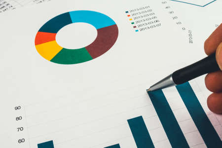 Businessman showing a diagram on a financial report using a penの写真素材